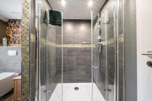 un bagno con doccia con porta in vetro di Küsten Suite Burghaus 5, 60qm a Krummhörn