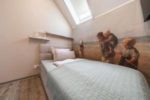 una camera da letto con un dipinto di due bambini e un letto di Küsten Suite Burghaus 5, 60qm a Krummhörn