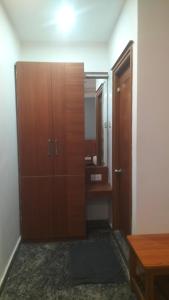 y baño con armario de madera y espejo. en MeDa-Frin's Hotel, en Chennai