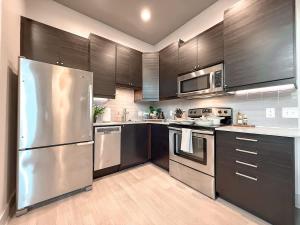 een keuken met roestvrijstalen apparatuur en houten kasten bij Central 1B1B Studio - Magnolia - Hospital District in Fort Worth