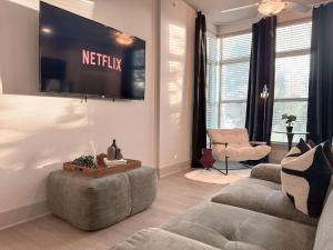 een woonkamer met twee banken en een flatscreen-tv bij Central 1B1B Studio - Magnolia - Hospital District in Fort Worth