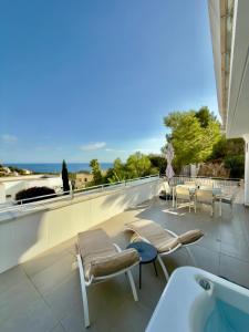 een balkon met een bad en stoelen en een tafel bij Casa del Sol in Altea