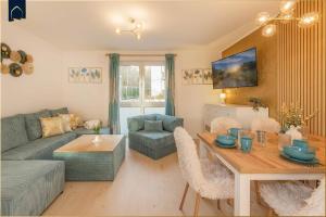 ein Wohnzimmer mit Sofa und Tisch in der Unterkunft Ferienwohnung Goldkind in Ostseebad Kölpinsee