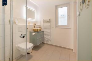 ein Badezimmer mit Toilette und Waschbecken und einem Fenster in der Unterkunft Ferienwohnung Goldkind in Ostseebad Kölpinsee + 39 Fotos