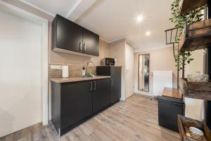 una cucina con armadi neri e pavimenti in legno di Küsten Suite Burghaus 5, 60qm a Krummhörn