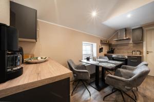 una cucina con un tavolo e sedie in una stanza di Küsten Suite Burghaus 5, 60qm a Krummhörn Altre 3 foto
