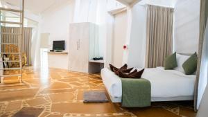 ein Wohnzimmer mit einer weißen Couch und einem grünen Stuhl in der Unterkunft Trisara Boutique Stay in Mysore