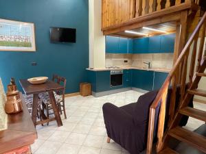una cucina con pareti blu, un tavolo e una scala di Montaria Suite a Pescocostanzo