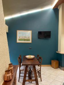 una sala da pranzo con tavolo e parete blu di Montaria Suite a Pescocostanzo