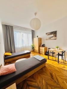 una sala de estar con dos camas y una mesa en Symphonia self check in 24h, en Katowice 10 fotos más