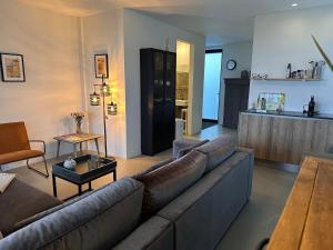 een woonkamer met een bank en een keuken bij Villa View in Alkmaar