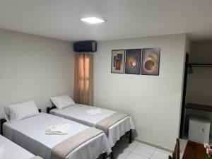 a hospital room with two beds and a window at Hotel Portal do Sertao in Feira de Santana