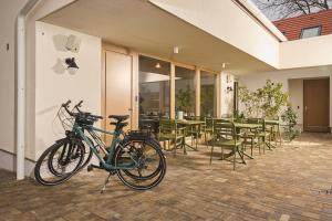 Una bicicleta estacionada al costado de un edificio con mesas y sillas. en Villa Bayer, en Villány