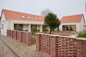 una casa con techo rojo y pared de ladrillo en Villa Bayer, en Villány