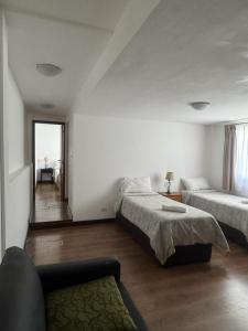 a bedroom with two beds and a couch in it at NBH Premier Hotel in San Carlos de Bariloche