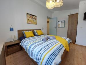 a bedroom with a large bed with yellow and blue sheets at House House Jadranovo in Jadranovo +37 photos