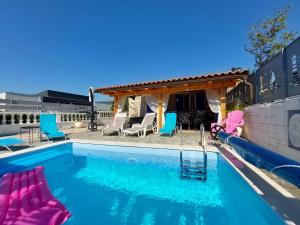 a swimming pool with chairs and a gazebo at House House Jadranovo in Jadranovo