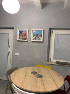 un tavolo in legno in una stanza con tre immagini sul muro di Vela Living a Civitanova Marche Altre 39 foto