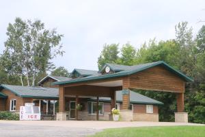 a log cabin with a sign in front of it at Econo Lodge Inn & Suites Munising Area in Wetmore