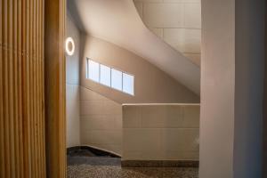 a bathroom with a shower and a staircase with a window at Pandora House in Mexico City