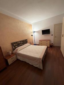 a bedroom with a bed and a flat screen tv at La casa di Alice in Orbassano