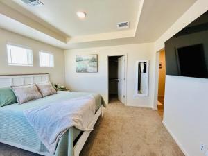 een slaapkamer met een bed en een flatscreen-tv bij Organ Mountain Loft 3BR 3 Steps into Golf Course in Las Cruces