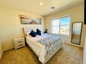 een slaapkamer met een bed met blauwe kussens en een raam bij Organ Mountain Loft 3BR 3 Steps into Golf Course in Las Cruces