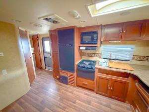 een keuken met houten kasten en een aanrechtblad bij Camper Adventure in Livingston