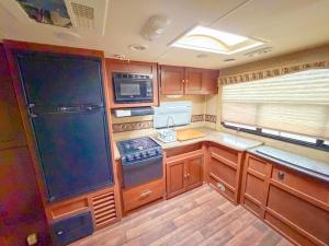 een keuken met houten kasten en een kookplaat met oven bij Camper Adventure in Livingston