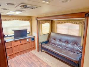een woonkamer met een bank en een flatscreen-tv bij Camper Adventure in Livingston
