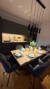 een eettafel met stoelen en een keuken bij Apartmány Horizont in Loučná pod Klínovcem