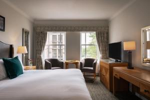a hotel room with a bed and a television at Rookery Hall Hotel & Spa in Nantwich