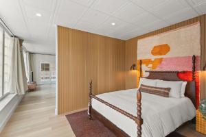 una camera da letto con un letto con una parete in legno di The Optimist Guesthouse | 1 a Camden