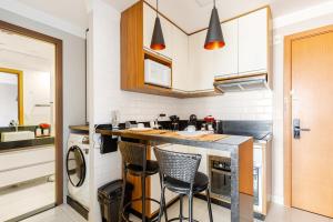 eine Küche mit einer Theke und ein paar Stühlen darin in der Unterkunft Modern Studio Garage 5 min to GRU Airport in Guarulhos