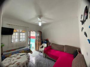 a living room with a couch and a tv at Casa de Praia Bertioga-Costa do Sol Guaratuba in Bertioga