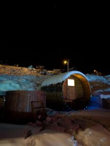 a wooden hobbit house with snow on top of it at Tuyo cottages Gudauri in Gudauri