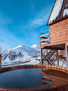 a mountain view from a house with a reflection in a pool at Tuyo cottages Gudauri in Gudauri