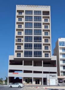 een hoog gebouw met een auto ervoor geparkeerd bij Modern & Elegant Fully Equipped Apartment in Sār