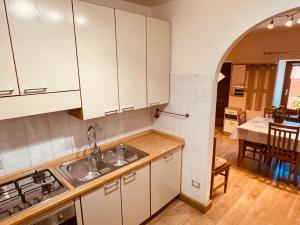 a kitchen with white cabinets and a sink and a table at Gran Paradiso Alpine Lodge in Aosta