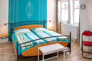 een slaapkamer met een bed en een blauwe muur bij Ferienwohnung-Margarete in Sankt Andreasberg