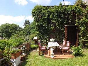 een patio met een tafel en stoelen in een tuin bij Ferienwohnung-Margarete in Sankt Andreasberg