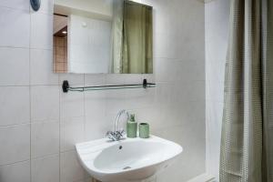 Un baño blanco con lavabo y espejo. en Hôtel des Touristes, en Pierrefitte-Nestalas 81 fotos más