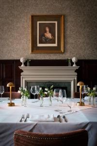 a table with a white table cloth and a portrait of a woman at Rookery Hall Hotel & Spa in Nantwich