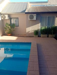 een huis met een zwembad voor een huis bij Brisas Iguazú II in Puerto Iguazú