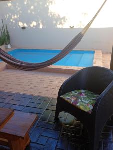 een hangmat en een stoel voor een zwembad bij Brisas Iguazú II in Puerto Iguazú