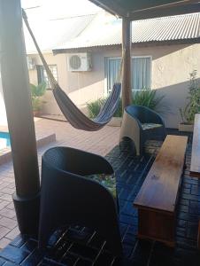 een patio met een hangmat en een tafel en stoelen bij Brisas Iguazú II in Puerto Iguazú