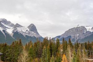 a mountain range with trees and snow covered mountains at Rundle Range Retreat Lux Mtn View Condo near dt in Canmore