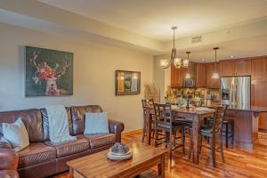a living room with a couch and a table at Rundle Range Retreat Lux Mtn View Condo near dt in Canmore +26 photos