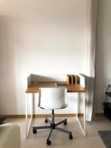einen Schreibtisch mit einem weißen Stuhl in einem Zimmer in der Unterkunft Apartment in Herborn mit Balkon & Weitblick ins Grüne in Herborn