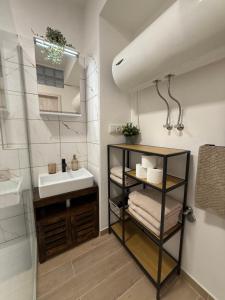 a bathroom with a sink and a shelf with towels at Apartmány U brány in Telč +48 photos